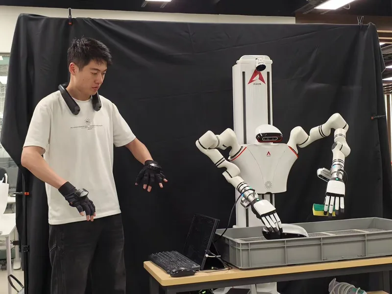 Side-by-side teleoperation with gloves and a neck tracker driving a dual-arm robot holding a sponge.