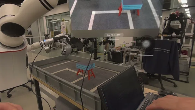 First-person view of a robot arm over a tray, with a top-down camera overlay and stop control.