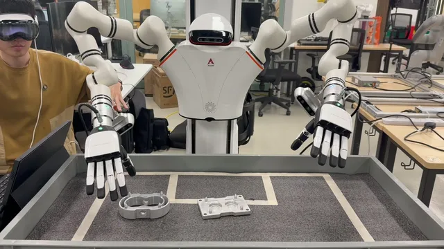 Operator in a mixed-reality headset teleoperating a dual-arm robot for insertion over metal parts.
