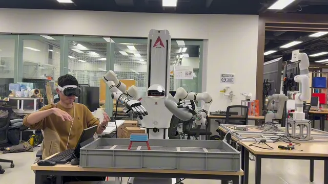 Operator in a Vision Pro teleoperating a dual-arm robot during a wiping task.