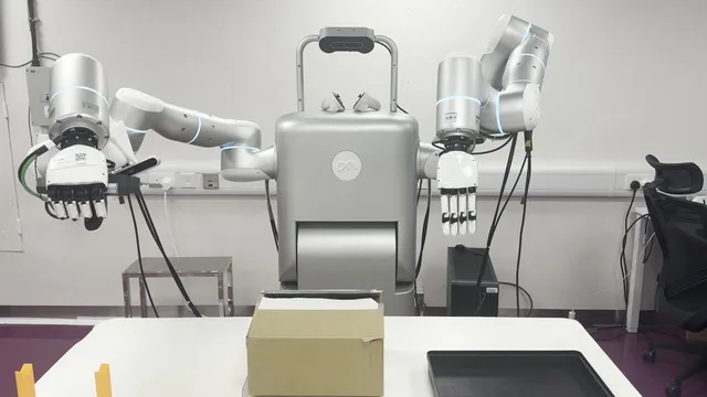 Unpacking cell with an open carton, a black tray, and VR controllers on the robot torso.